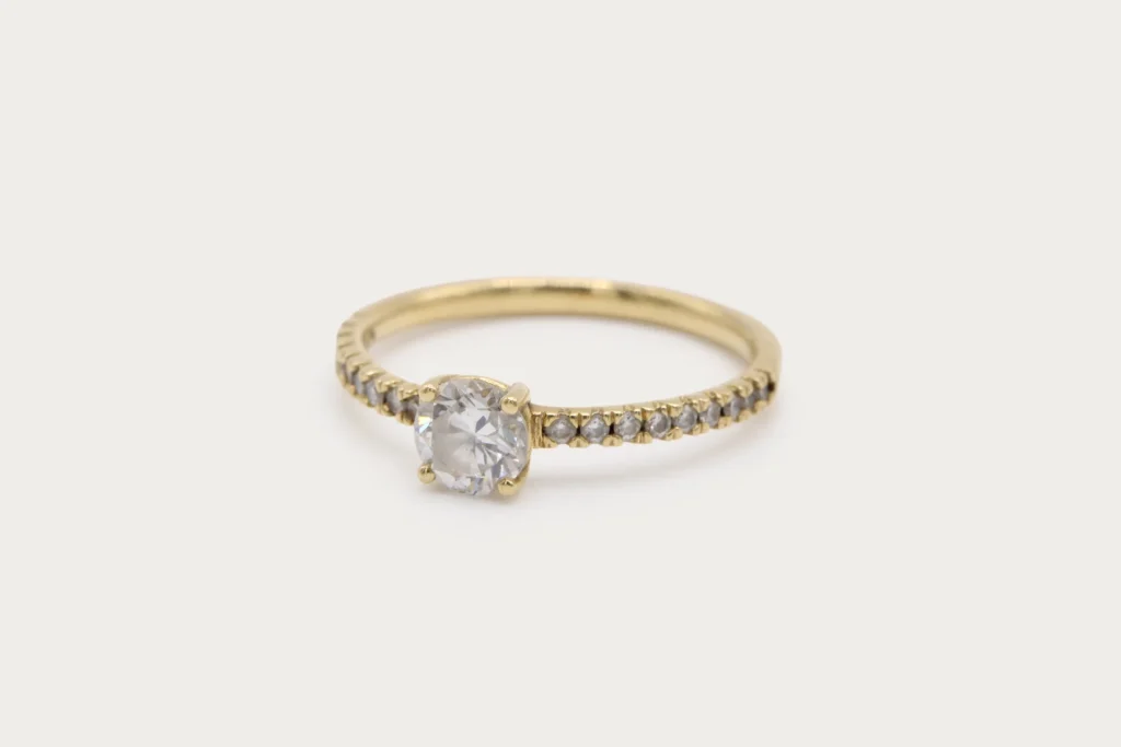 Anillo solitario de oro amarillo 18k con diamante central de 0.34ct y 18 diamantes en pavé en el brazo