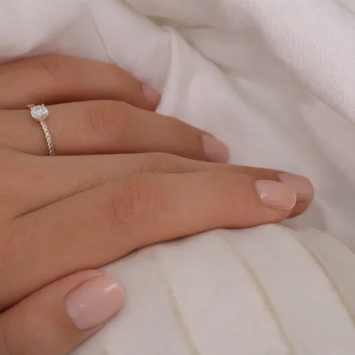 Anillo solitario de oro amarillo 18k con diamante central de 0.34ct y 18 diamantes en pavé en el brazo