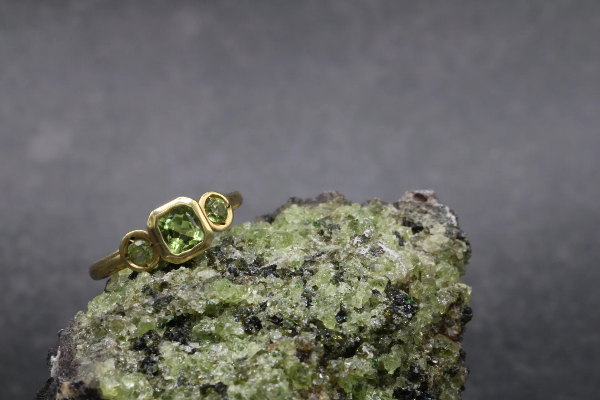 anillo-oro-amarillo-9k-peridoto-trilogia-cushion (3) Anillo trilogía de oro amarillo 9k con peridoto central talla cushion y dos peridotos redondos en engaste bisel