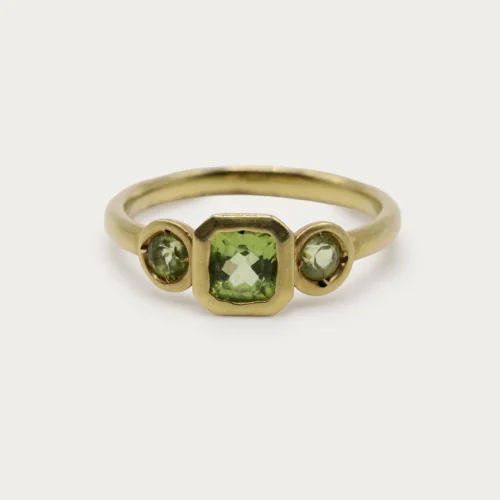 Anillo trilogía de oro amarillo 9k con peridoto central talla cushion y dos peridotos redondos en engaste bisel