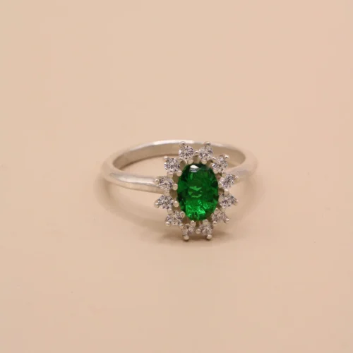 Anillo rosetón de oro blanco 18k con esmeralda central de 7x5mm y halo de 12 diamantes H/VS
