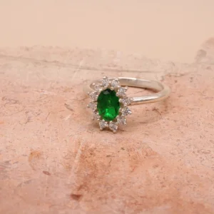 Anillo rosetón de oro blanco 18k con esmeralda central de 7x5mm y halo de 12 diamantes H/VS