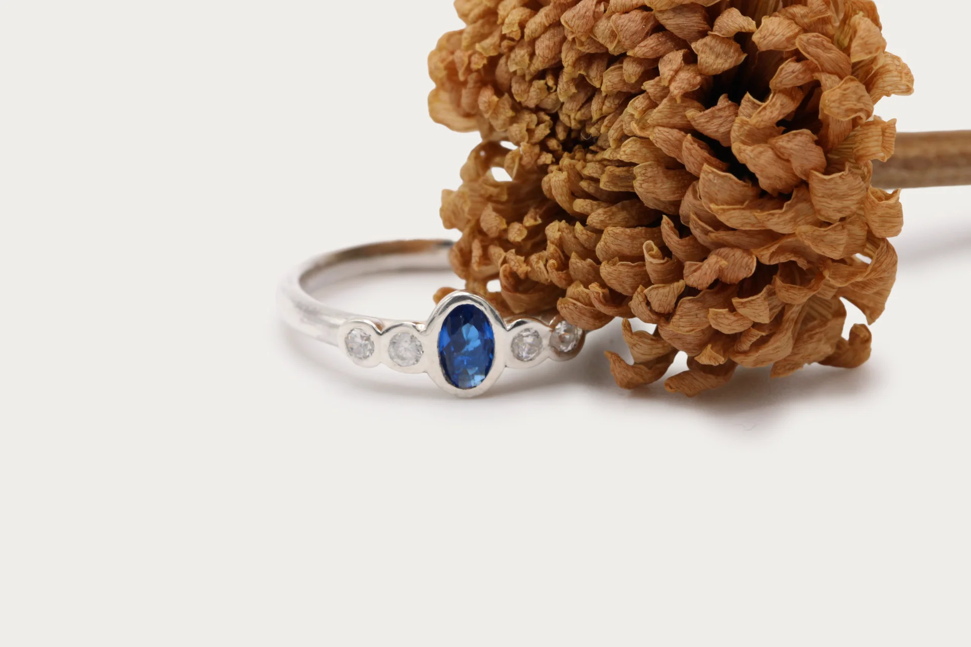 anillo-oro-blanco-18k-zafiro-diamantes-brillante (2) Anillo de oro blanco 18k con zafiro central azul y cuatro diamantes talla brillante G/VS, engaste en bisel