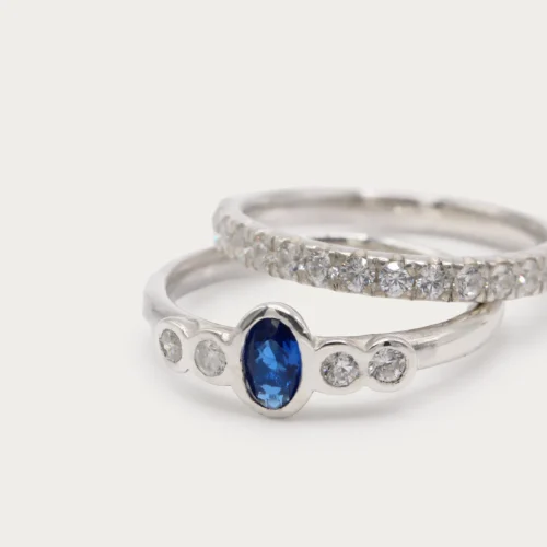 Anillo de oro blanco 18k con zafiro central azul y cuatro diamantes talla brillante G/VS, engaste en bisel