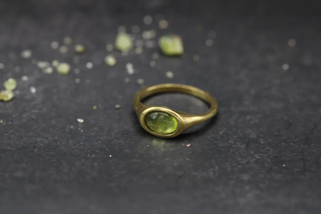 Anillo signet de oro amarillo 9k con peridoto cabujón oval de 6x4mm engaste integrado