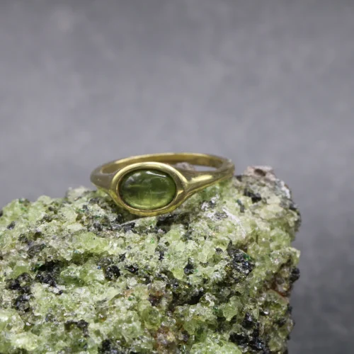 Anillo signet de oro amarillo 9k con peridoto cabujón oval de 6x4mm engaste integrado