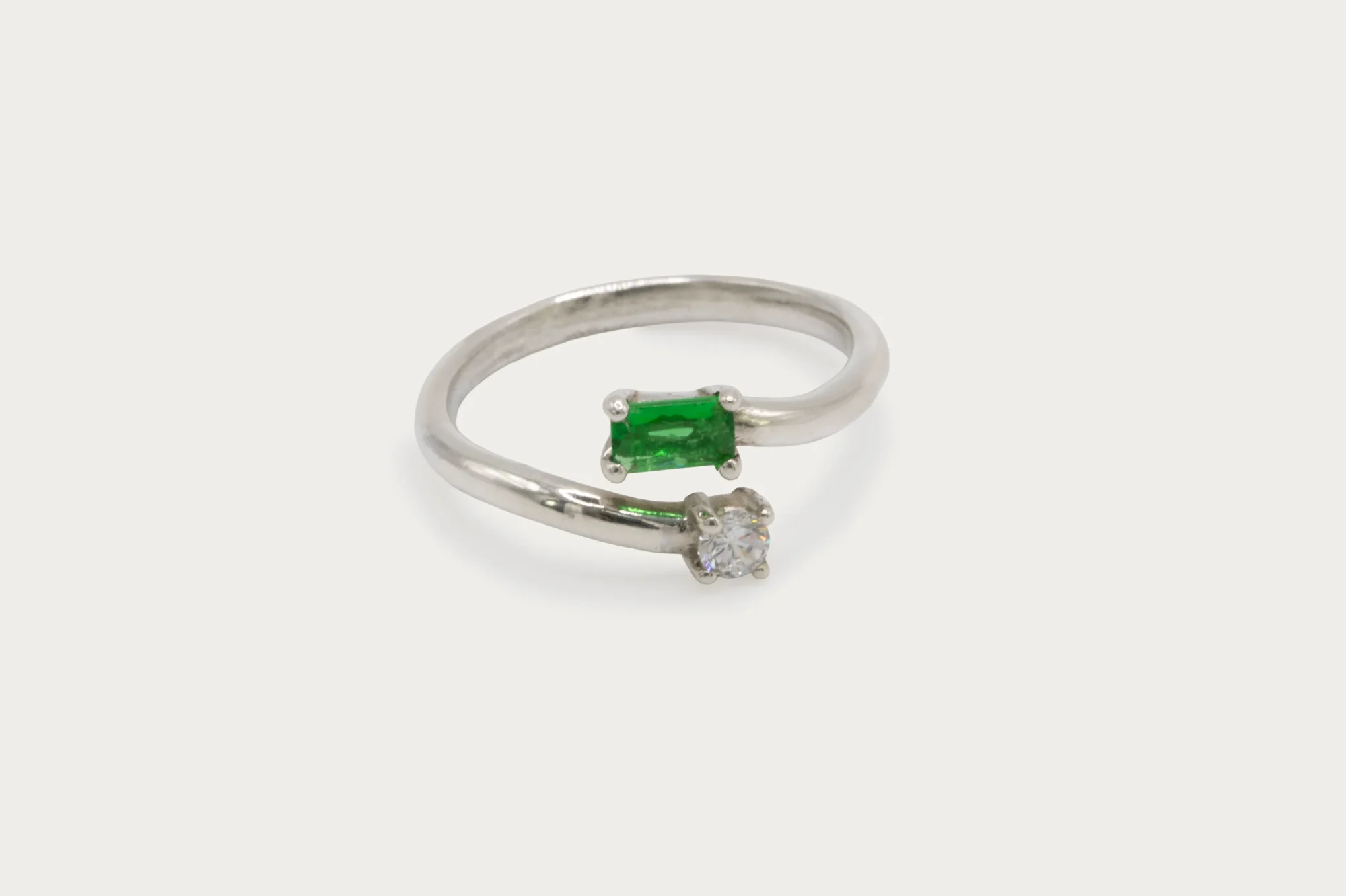 Anillo toi et moi de oro blanco 18k con esmeralda talla baguette y diamante redondo de 3mm en diseño abierto